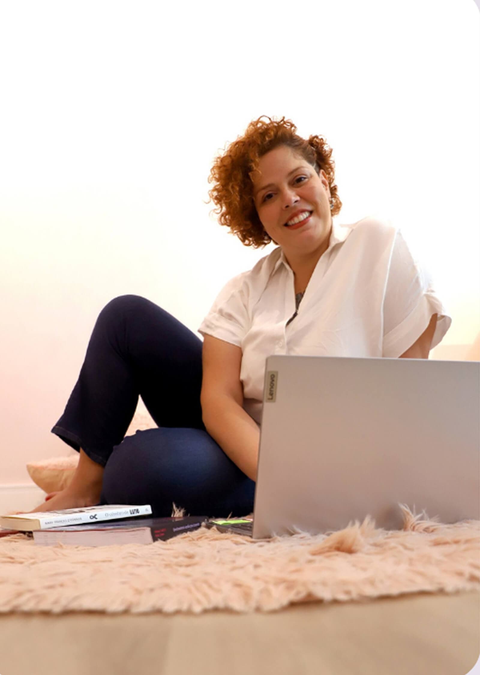 Amanda Cambuí sorrindo com notebook, em atendimento online